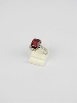 une bague en or blanc sertie d'une pierre rouge et de diamants