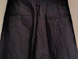 navy blue pants hanging on a hanger in a white room