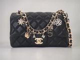 Sac à main Chanel en cuir matelassé noir, avec chaîne dorée et breloques