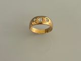 une image d'une bague en or avec des diamants sur une surface blanche