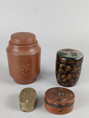 trois petits pots et un petit récipient sont posés sur une surface blanche