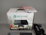 a box with a game controller and a charger on it