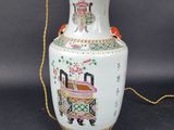 a white vase with a gold handle on a table