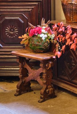 un panier de fleurs posé sur une table à côté d'une commode