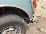 a close up of the tire of a blue pick up truck