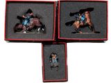 three miniature figurines of a man riding a horse in a box