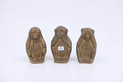 trois figurines en bronze représentant trois singes sur fond blanc