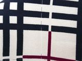 a close up of a black and white checkered shirt with a red stripe