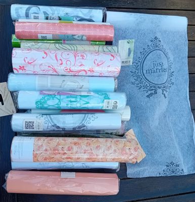 many rolls of fabric sitting on a table next to a book