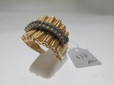 gros plan d'une bague en or avec des diamants sur une surface blanche