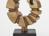 une image représentant une sculpture représentant un objet circulaire posé sur un socle