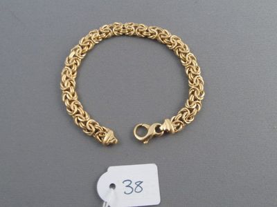 gros plan d'un bracelet en chaîne en or avec une étiquette de prix