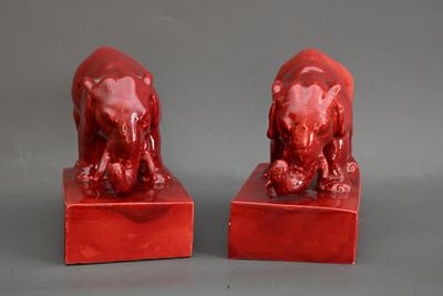 paire de serre-livres en forme d'éléphants en céramique rouge, posés sur des socles en marbre rouge