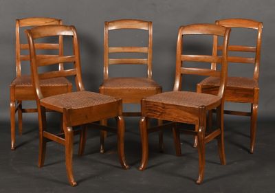 quatre chaises en bois disposées les unes à côté des autres sur une surface grise