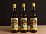 trois bouteilles d'huile d'olive posées sur une table en bois