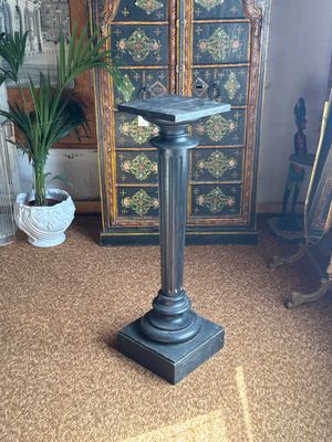 a black pedestal with a birdbath on top of it
