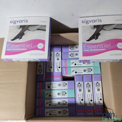 Plusieurs boîtes contenant des bas de différentes tailles et couleurs sont empilées les unes sur les autres.