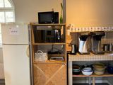 une petite cuisine équipée d'un réfrigérateur, d'un micro-ondes et d'autres appareils électroménagers