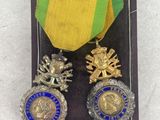 two medals are in a case on a white surface