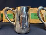 three silver pitchers sitting next to each other on a table