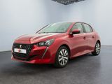 Une voiture rouge est garée dans une pièce blanche au sol noir.