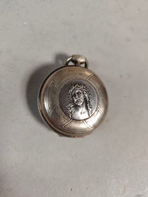 an image of a silver pocket watch with a picture of a man on it