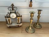 trois bougies et une horloge posées par terre