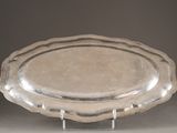 a silver plate on a metal stand on a table