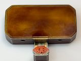 a small brown case with a red flower on it