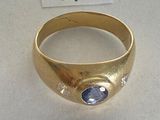 an image of a gold ring with a blue stone on it