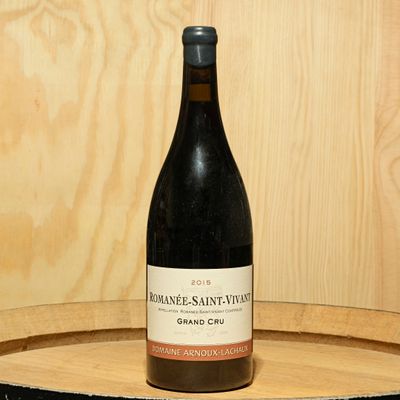 a bottle of wine sitting on top of a wooden barrel