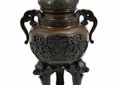 a bronze urn with a peacock on it