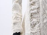 a close up of a white dress with ruffles on it