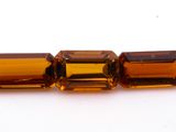 un gros plan sur trois perles rectangulaires en citrine posées sur une surface blanche