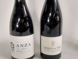 two bottles of red wine sitting next to each other on a table