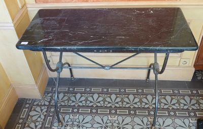 une petite table avec un plateau en marbre, dans un coin de la pièce