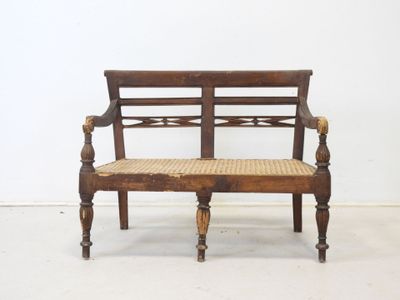 a wooden bench with a wicker seat on it