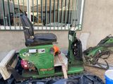 a green scooter parked next to a trash can