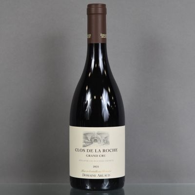 a bottle of red wine sitting on top of a glass table