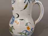 a white vase with blue and yellow flowers on it