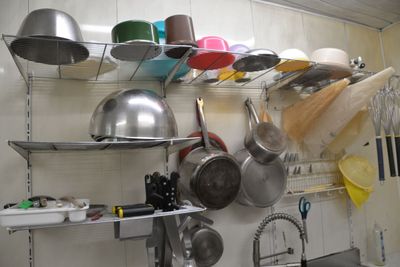 many pots and pans hanging on the wall in the kitchen