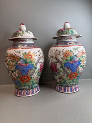 une paire de vases chinois ornés de motifs colorés, posés sur une étagère