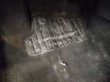 a dirty car floor with a rubber mat on it