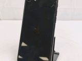 a broken iphone sitting on a stand on a table