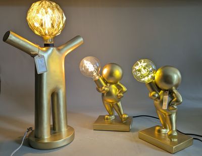 three gold figurines that are on a table