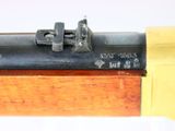 a close up of a rifle with a yellow handle