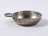 an antique silver plate with a handle and a flower design on it