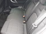 the back seats of a car with a bottle of beer in the passenger seat