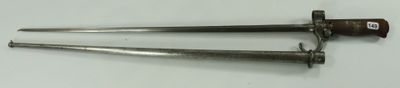 pair of old metal nails on a white surface with a red handle