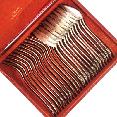 une boîte rouge contenant un service de cuillères en argent